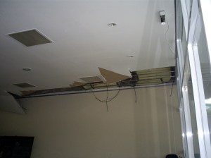 No saguão de entrada, o flagra. Um pedaço da cobertura do teto foi arrancado à mão, e a fiação elétrica cortada.