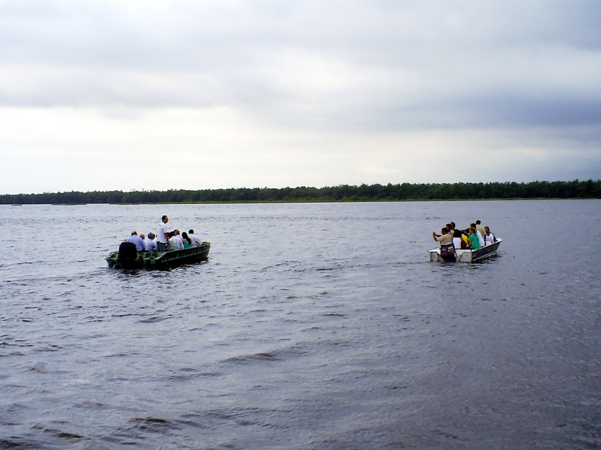 À direita, barco com jornalistas que virou no mar em São Vicente. (Foto: Allan Nóbrega)